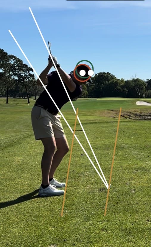 Top of backswing with swing-plane lines drawn by a coach